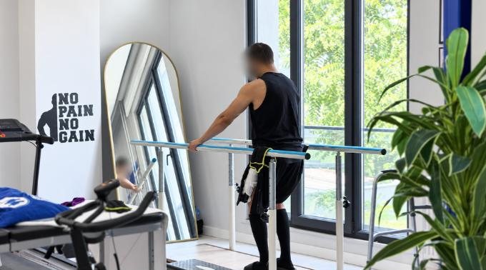 Patient walking between parallel bars, side view